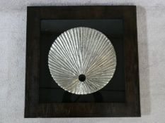 A contemporary carved wood textured silver disk, mounted on black, shadow box framed. 80x80cm