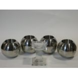 A set of four chrome spherical candle holders and a glass pedestal candle holder. H.14xW.10xL.10cm