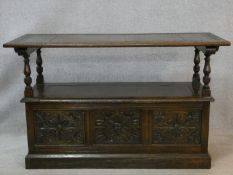 A mid century carved oak monk's bench converting to centre table with lift up coffer section to