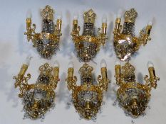 A set of six gilt metal twin branch wall candelabras with crystal drops. H.38cm