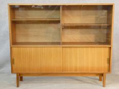 A 1960's vintage teak Beaver and Tapley Multi Width display cabinet on shaped splay supports. H.