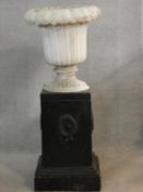 A painted reconstituted stone floral design garden urn on plinth base. H.102 D.43cm