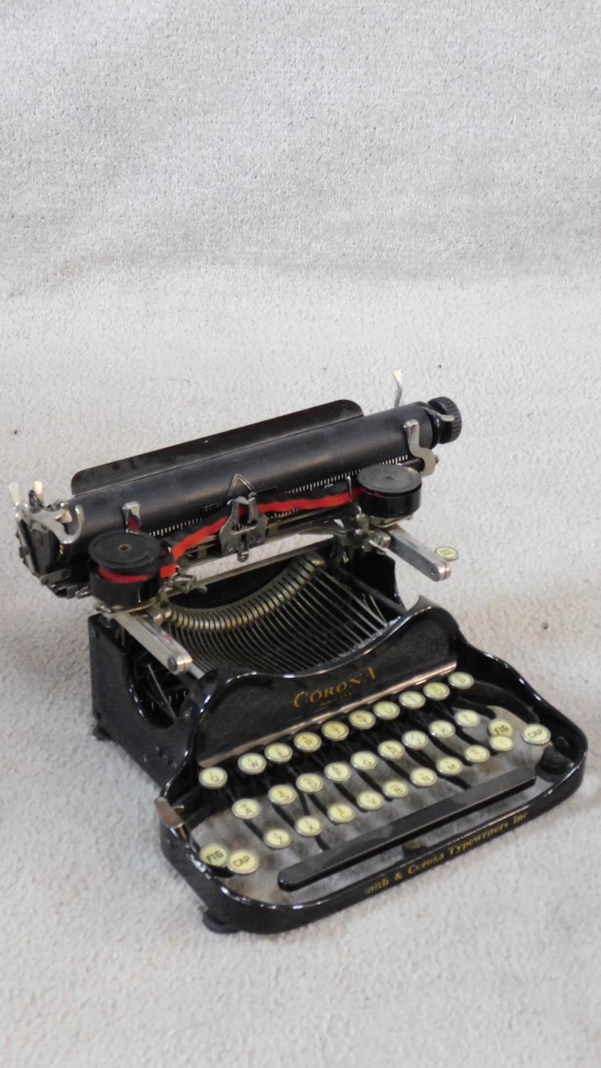 Corona black enamel metal typewriter inscribed L C Smith & Corona Typewriters Inc, in carrying case.