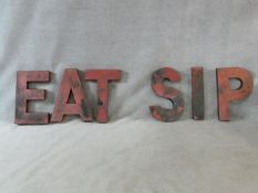 A set of six large red painted metal vintage shop front letters. One word reads' Eat' and one 'Sip'.