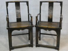 A pair of mid century Chinese hardwood armchairs with carved character marks to the back splats