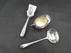 Three silver plated items; a pair of engraved asparagus tongs, a ladle and a milk jug. L.27cm