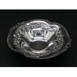 A Greek silver repousse floral design bowl on three pierced scrolling feet. Marked 'EPT, XEIPO,