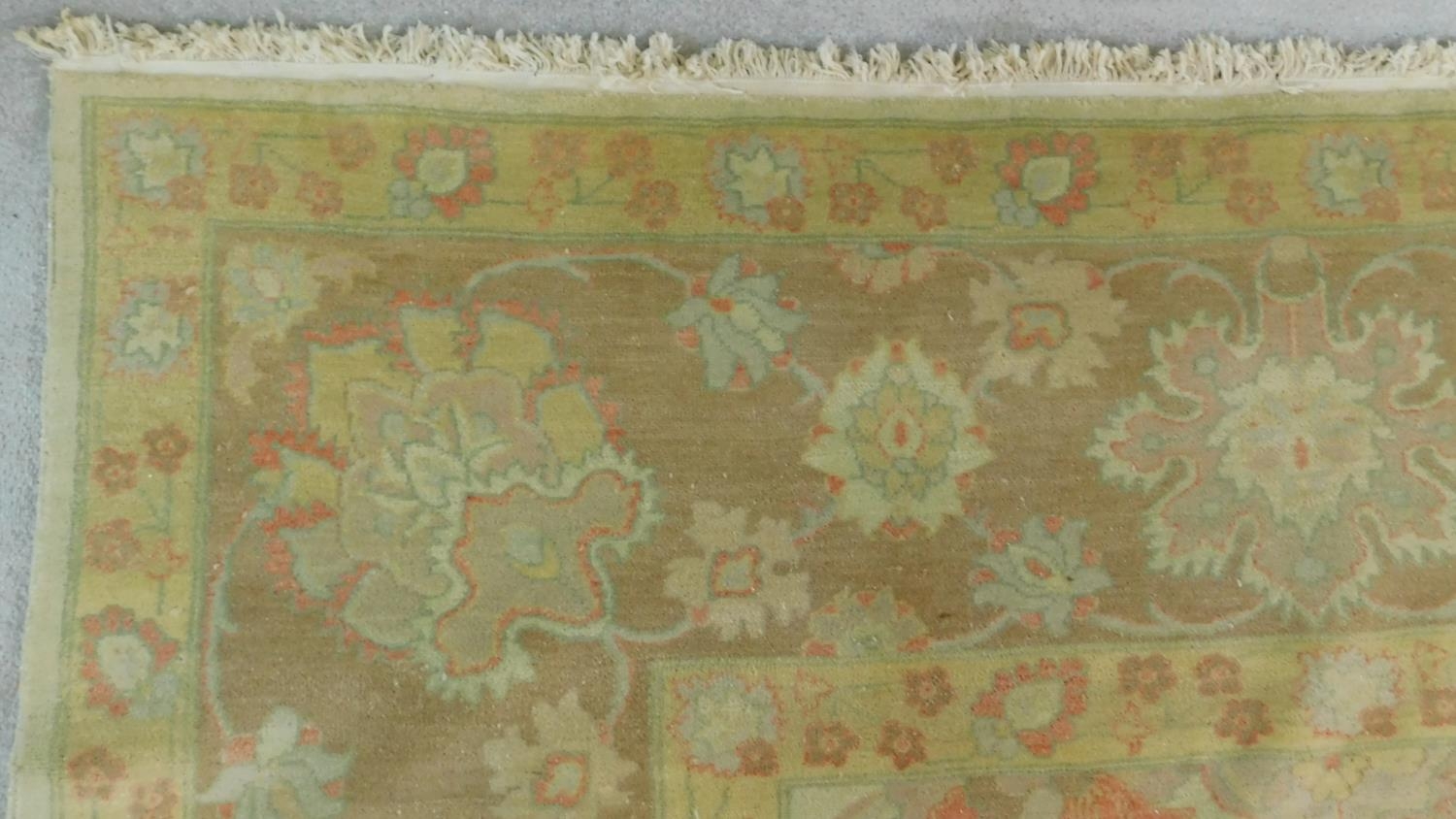 A large Ziegler style carpet with all over scrolling vine, palmette and floral decoration to the - Image 3 of 4