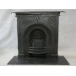 An ornately cast 19th century iron fire surround, mantel shelf and insert with grate on marble