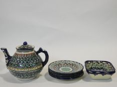 An Uzbec glazed and hand painted colourful ceramic tea set; tea pot, four side plates and a pair