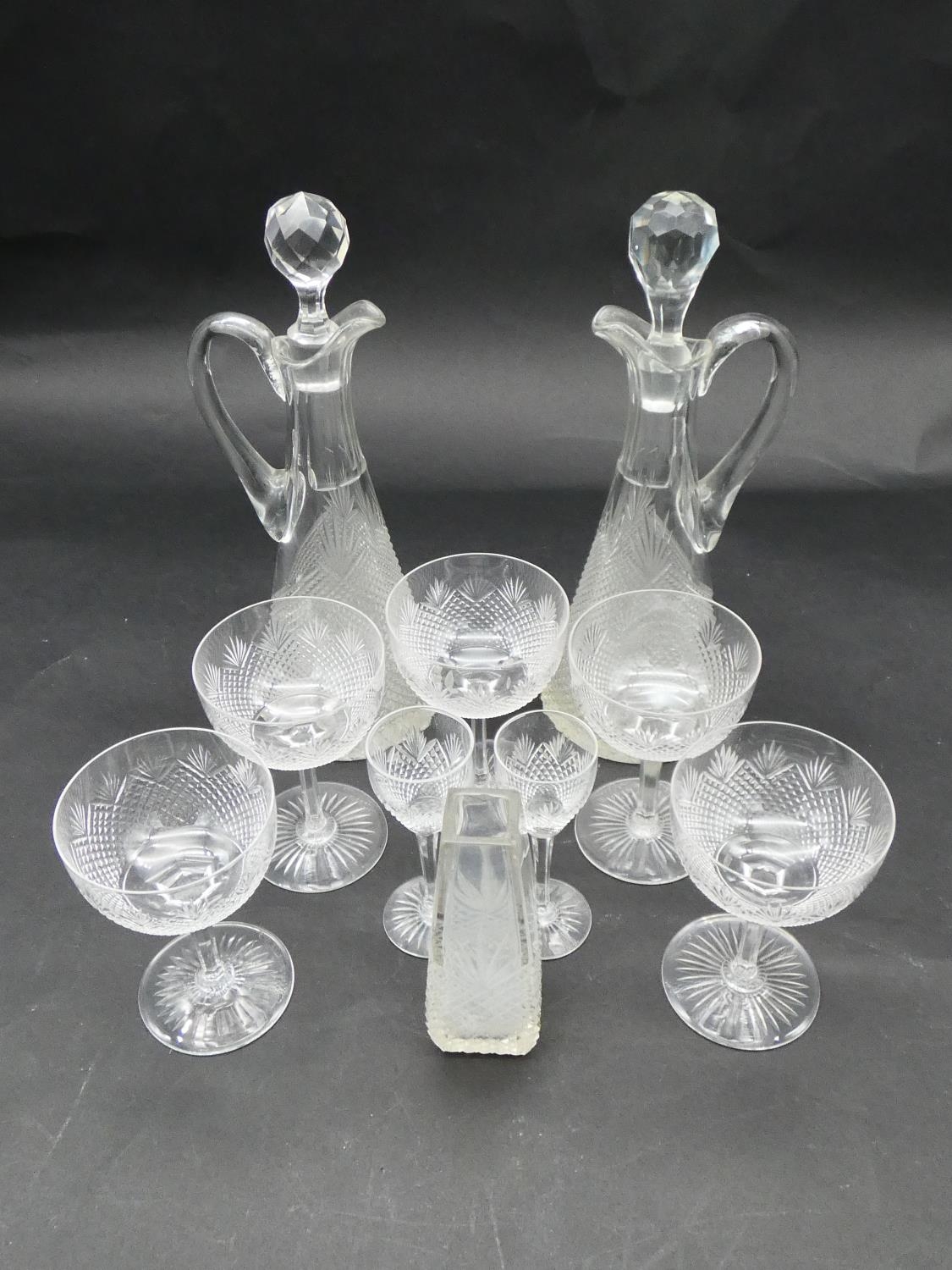 A collection of antique hand cut crystal glassware. Including two handled decanters, five