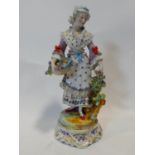 A Meissen style porcelain hand painted figure of a flower girl with her basket and bunch of flowers,