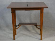 An Edwardian mahogany and satinwood strung fold over top tea table on square tapering supports. H.