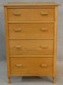 A mid century light oak bedroom chest of four drawers on turned peg feet. H.89 W.61 D.43cm