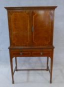 A Georgian style mahogany and satinwood strung cocktail cabinet with mirrored and shelved interior