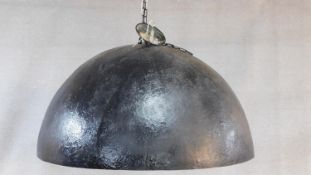 A very large contemporary domed black fibreglass ceiling light with textured and gilded interior.