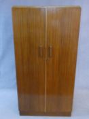 A 1960's fitted teak compactum wardrobe with inset Heal's disc to the inside of door. H.178 W.92 D.