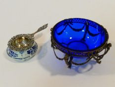 A Dutch repousse floral design pierced silver tea strainer with white and blue ceramic bowl, along