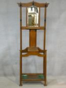 A late 19th century oak hallstand fitted with mirror, lift up glove box and umbrella compartments