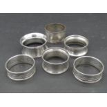 A collection of silver napkin rings. Two with a pierced Greek key design, hallmarked: HG&S for Henry