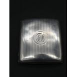 An Edwardian silver cigarette case with linear engine decoration and circular cartouche with