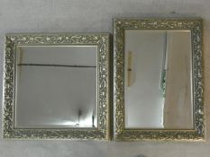 A bevelled glass wall mirror in silvered floral frame and a similar wall mirror. H.91 W.68cm (