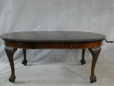 A mid century mahogany Georgian style dining table with gadrooned edge, wind out action and extra