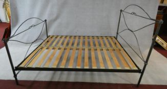 A wrought iron bedstead with support slats, to take a 5 ft mattress.