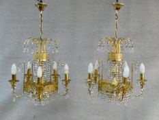 A pair of gilt metal five branch chandeliers with crystal drops. H.80 D.44cm