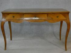 A Louis XV style walnut bureau plat with quarter veneered top and three frieze drawers raised on