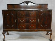 A mid century flame mahogany sideboard with cupboards and drawers on carved cabriole supports. H.125