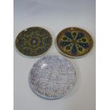Two Islamic glazed plates and a terracotta Art Pottery charger, each hand decorated. D.33cm