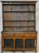 A Georgian country oak dresser with open plate rack above base fitted with three frieze drawers