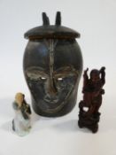A carved wooden African tribal mask along with a carved wooden Chinese immortal and a ceramic figure
