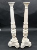 A pair of white painted and carved ecclesiastical candlesticks. H.60cm