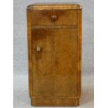 An Art Deco figured walnut pot cupboard with frieze drawer above panel door on plinth base. H.69 W.