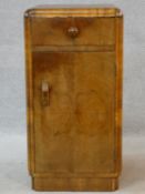 An Art Deco figured walnut pot cupboard with frieze drawer above panel door on plinth base. H.69 W.