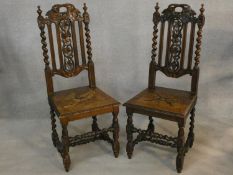 A pair of late 19th century Carolean style hall chairs with carved backs and panel seats on