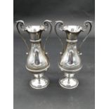 A pair of Victorian twin scrolling handled silver urn vases with beaded detailing and scalloped