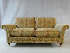 A large Parker Knoll two seater Burghley sofa in Baslow Medalli gold upholstery raised on turned