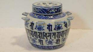 A blue and white Chinese Sanskrit ceramic burial jar with cover decorated with waves and eight