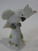 A 19th century Meissen hand painted porcelain cockatoo. With red crest and perched on a log. First