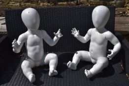 A pair of seated child mannequins. H.55cm