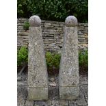 A pair of large weathered reconstituted stone garden obelisks topped with removable spheres. H.132cm
