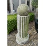 A moulded concrete classical column style plinth with weathered spherical finial. H.128cm