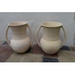 A pair of Persian earthenware twin handled urns of bulbous form. H.66cm