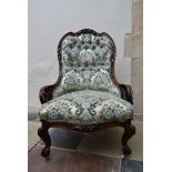 A Victorian mahogany nursing chair with carved and pierced back rail on cabriole supports in deep