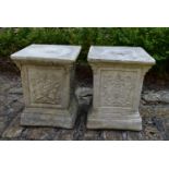 A pair of stepped garden plinths with armorial decoration. H.42xW.34cm