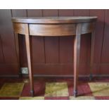 A Georgian mahogany and satinwood crossbanded demi lune tea table with fold over top on square