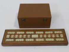 A 19th Century parquetry and bone inlaid cribbage board and pieces along with a wooden cased antique